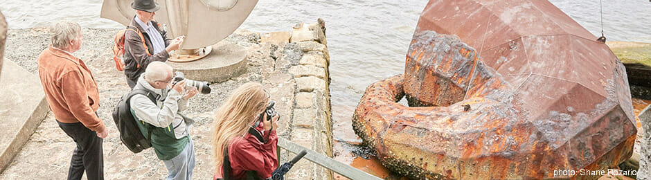 People photographing a huge rock.